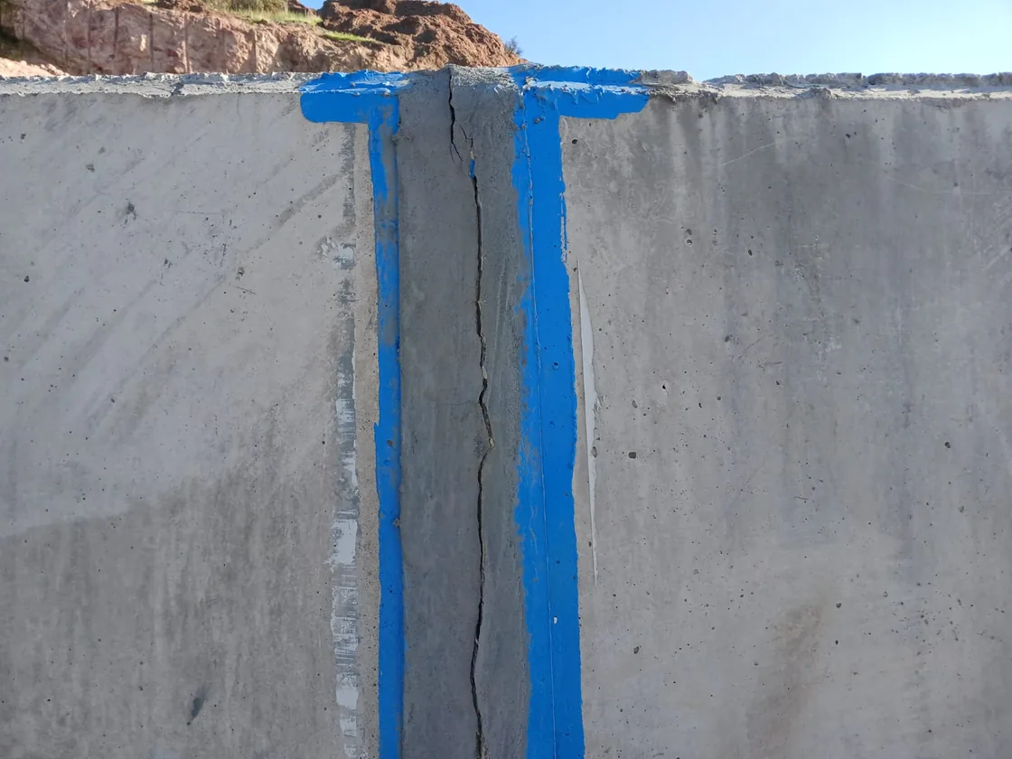 Muro de hormigón con una fisura vertical marcada y filtración de agua