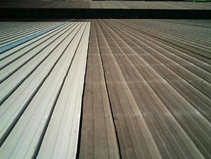 Foto real de la misma cubierta en el mismo momento: la mitad izquierda pintada de blanco con Super Therm y la mitad derecha de zinc sin tratar