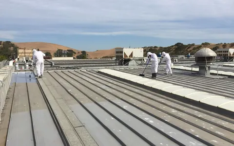 Equipo de DeltaPaint aplicando recubrimiento sobre una cubierta metálica industrial